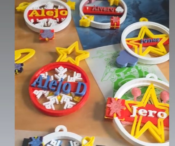 Adornos navideños impresos en 3D con nombres: Alejo, Álvaro, Alejo D y Jero, con estrellas amarillas, copos blancos y regalos rojos