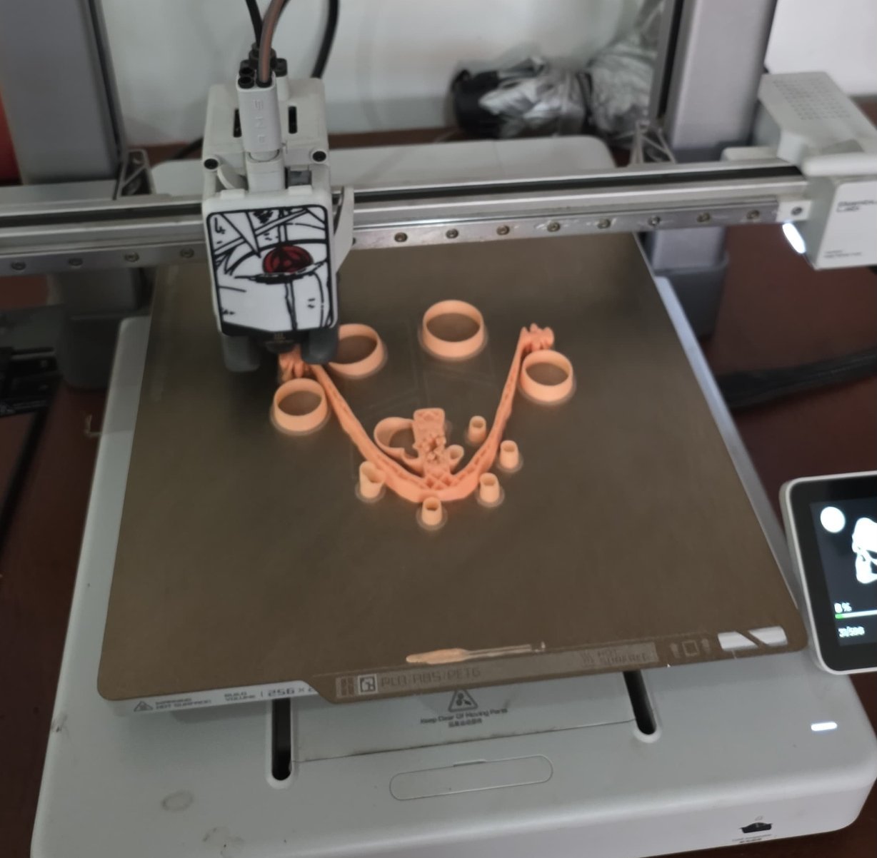 La impresora 3D del club imprimiendo en filamento coral las piezas de una máscara