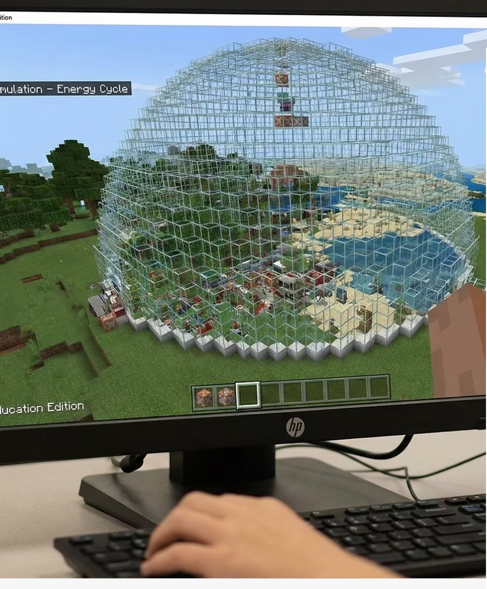 Pantalla con la biosfera construida en Minecraft Education: una cúpula de vidrio con un ecosistema adentro