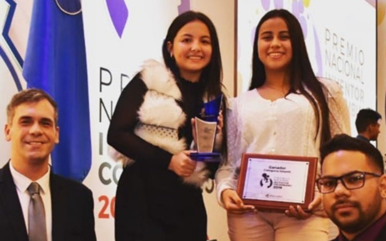Dos de las investigadoras del club con el trofeo y la placa del Premio Nacional al Inventor Colombiano 2019, junto a sus docentes